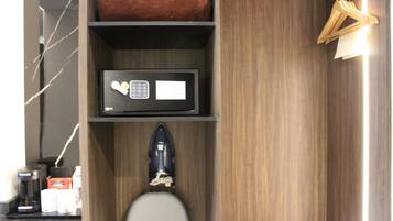A bathroom with a toilet, a shelf with a microwave, a bottle of hand soap, and a towel rack.