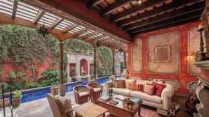 A cozy living area with a pool, comfortable seating, and a fireplace. - Hotel Posada del Angel (Antigua Guatemala)