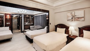 Habitación de hotel con dos camas, un sofá, un escritorio y un baño.