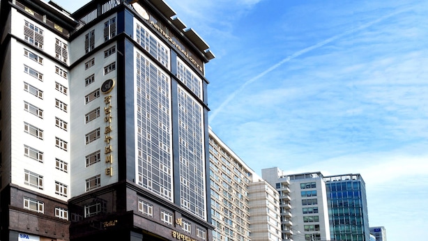 Un hotel de varios pisos con diseño moderno, con amplias ventanas y un letrero llamativo.