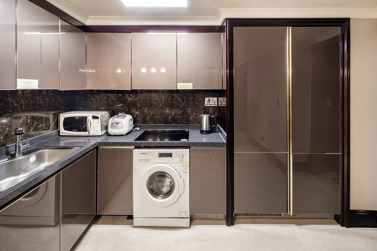 Eine moderne Küche mit Einbauwaschmaschine, Mikrowelle und Toaster.