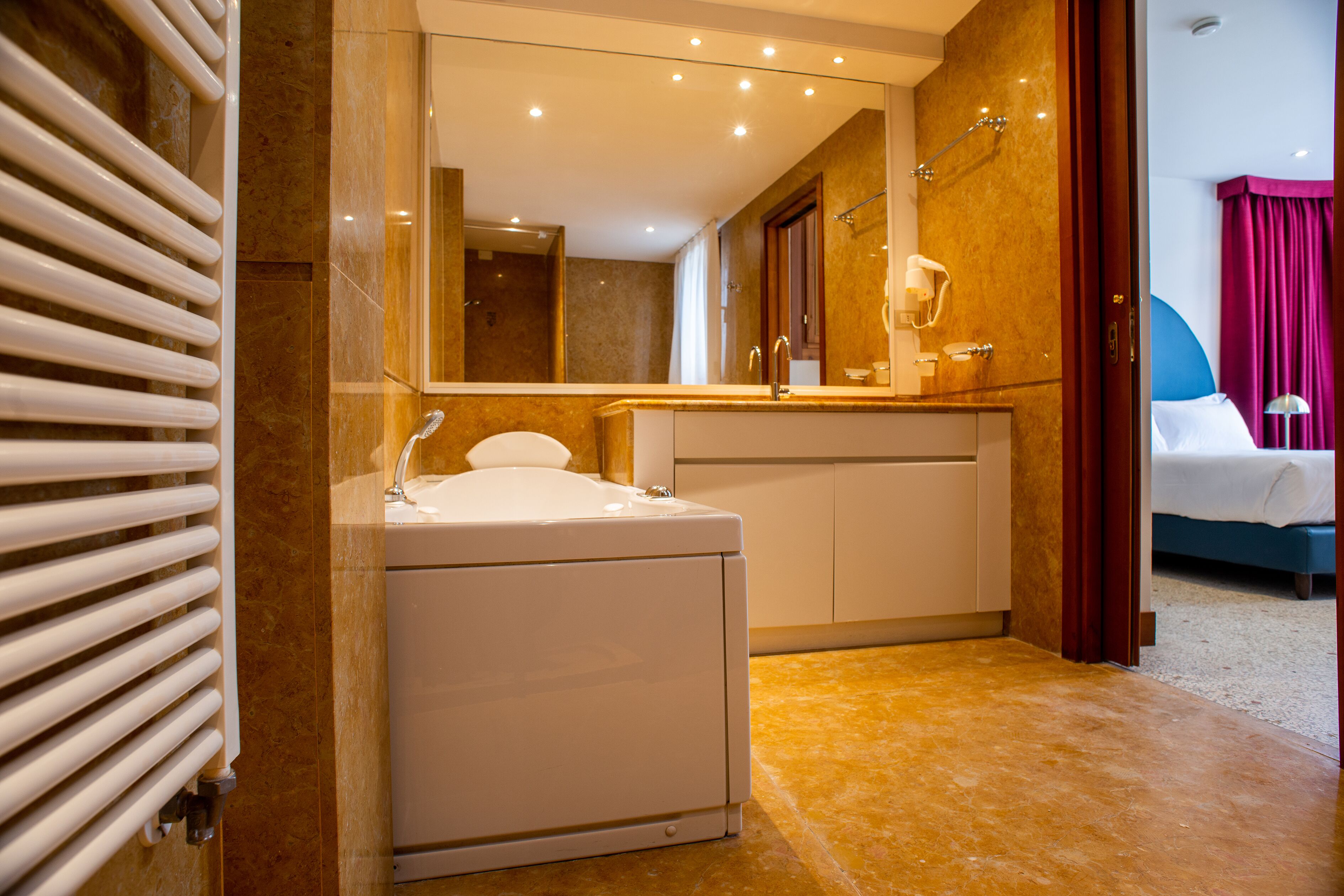 A modern bathroom with a built-in bathtub, a large mirror, and a shower area.