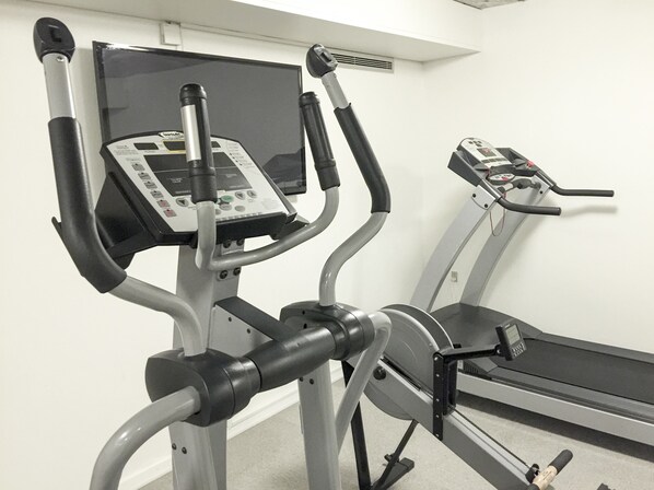 A gym with stationary bikes and treadmills, equipped with control panels. - Kysthotellet Djursland (Grenaa)