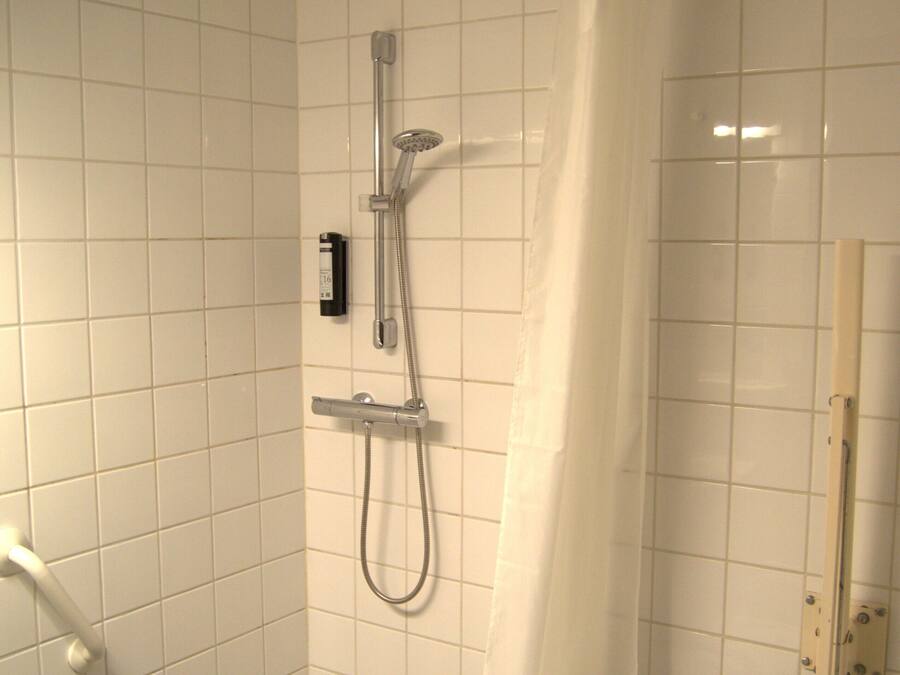 Ein kleines Badezimmer mit Fliesen, einer Dusche, einer Toilette und einem Waschbecken.
