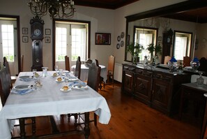 Enjoy meals in this elegant dining room with a long table, comfortable chairs, and a beautiful chandelier.