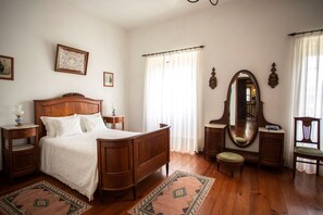 Cozy retreat with a comfortable bed, nightstands, and a dresser, plus a mirror above.