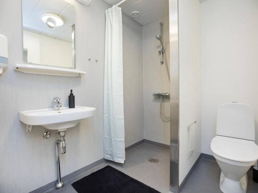 Ein Badezimmer mit einem weißen Waschbecken, einer Toilette und einer Duschkabine.