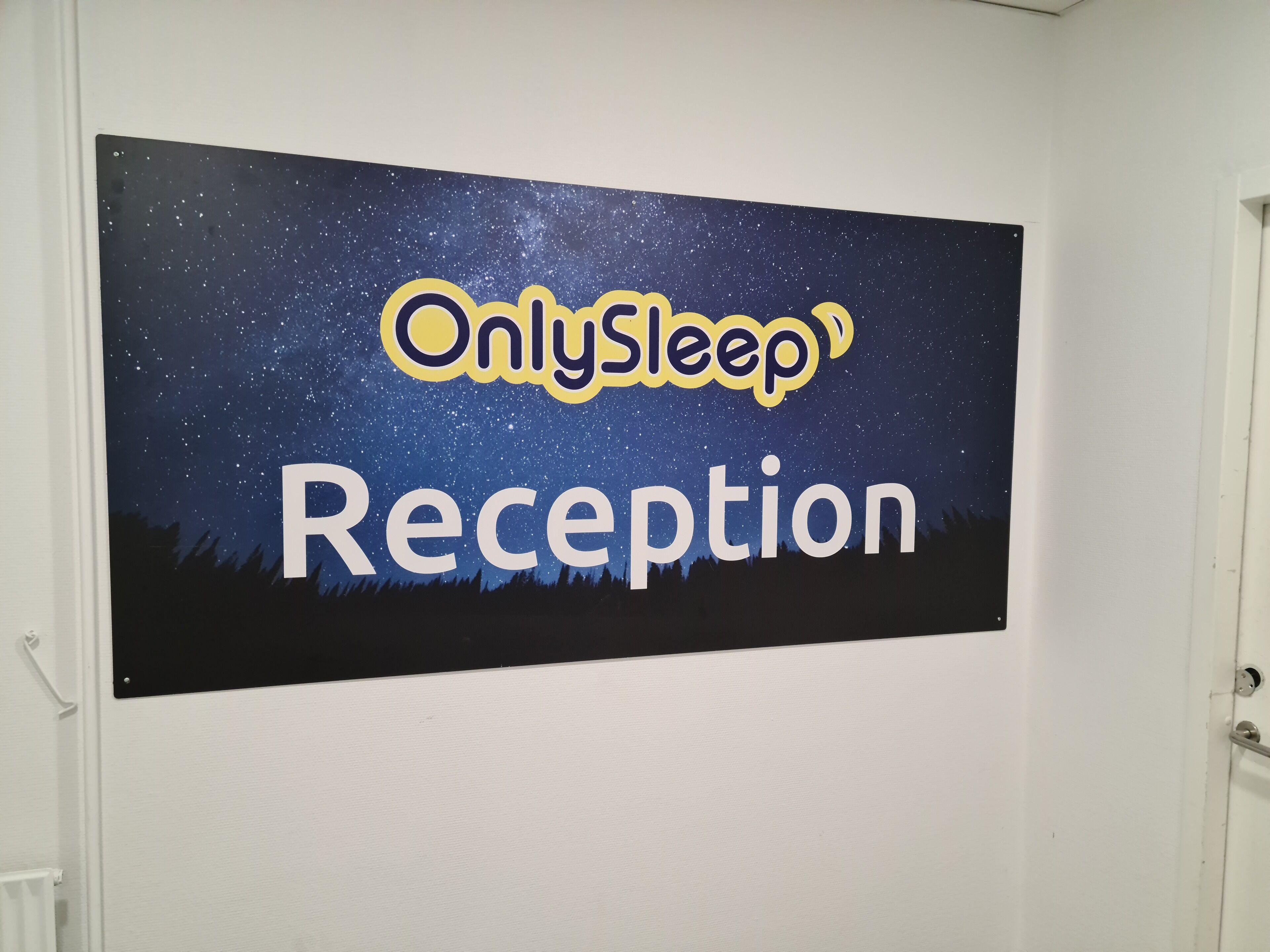 Un letrero con el texto 'OnlySleep Reception' sobre un fondo de noche estrellada.