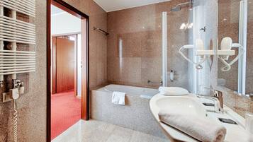 Ein modernes Badezimmer mit einer Badewanne, einem großen Spiegel und einem Waschtisch.