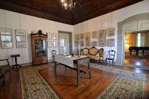 A room with wooden floors, a table with chairs, a cabinet with glass doors, and framed pictures on the walls. - Casa do Condado de Beirós (Sao Pedro do Sul)