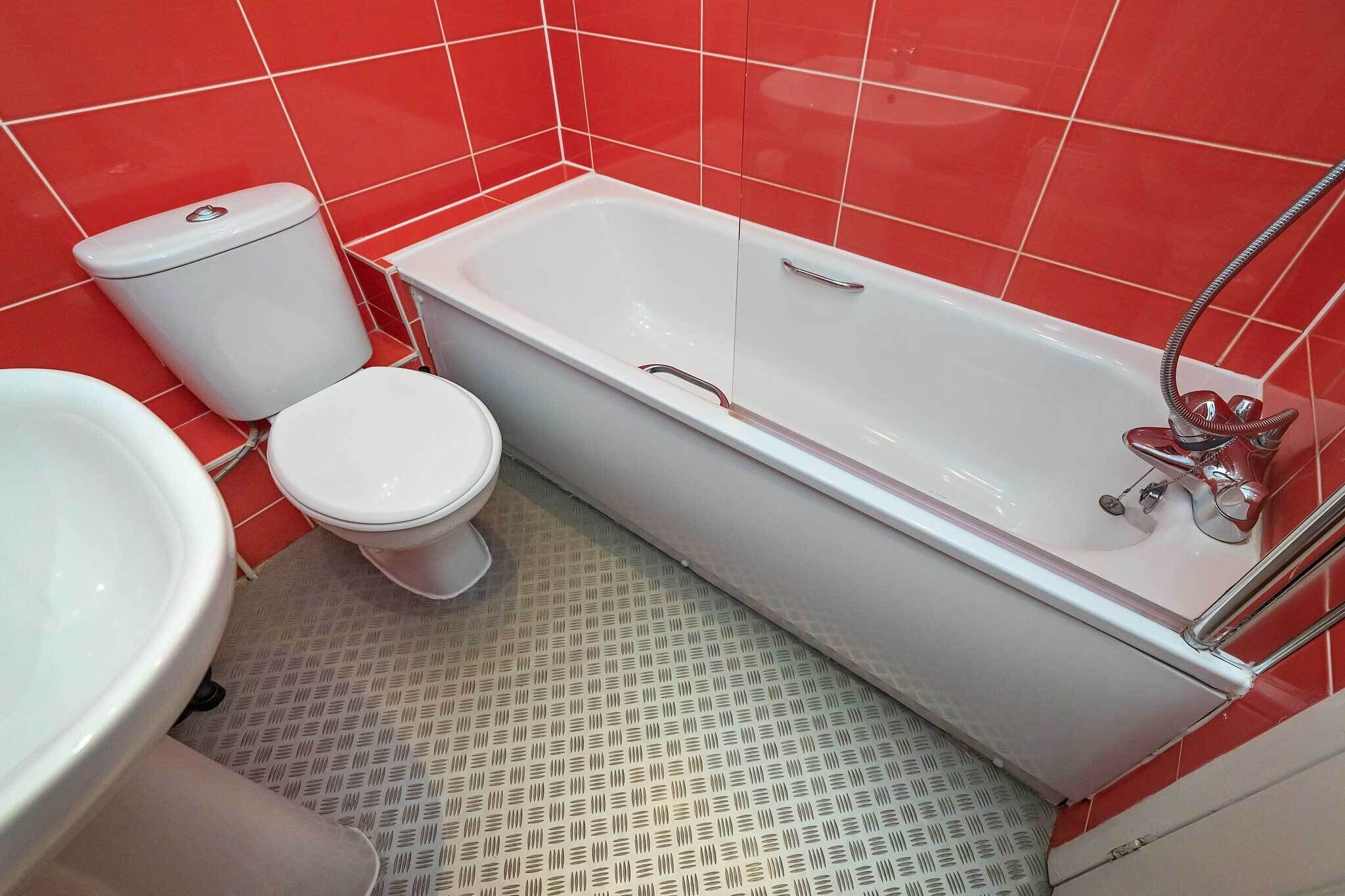 Une salle de bain avec une baignoire blanche, des toilettes et un lavabo.