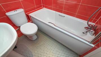 Une salle de bain avec une baignoire blanche, des toilettes et un lavabo.