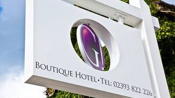 Schild für das Boutique Hotel mit Telefonnummer.