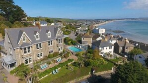 A coastal residential area with houses, a swimming pool, and a beach. - Hotel Penzance Harbour View (Penzance)