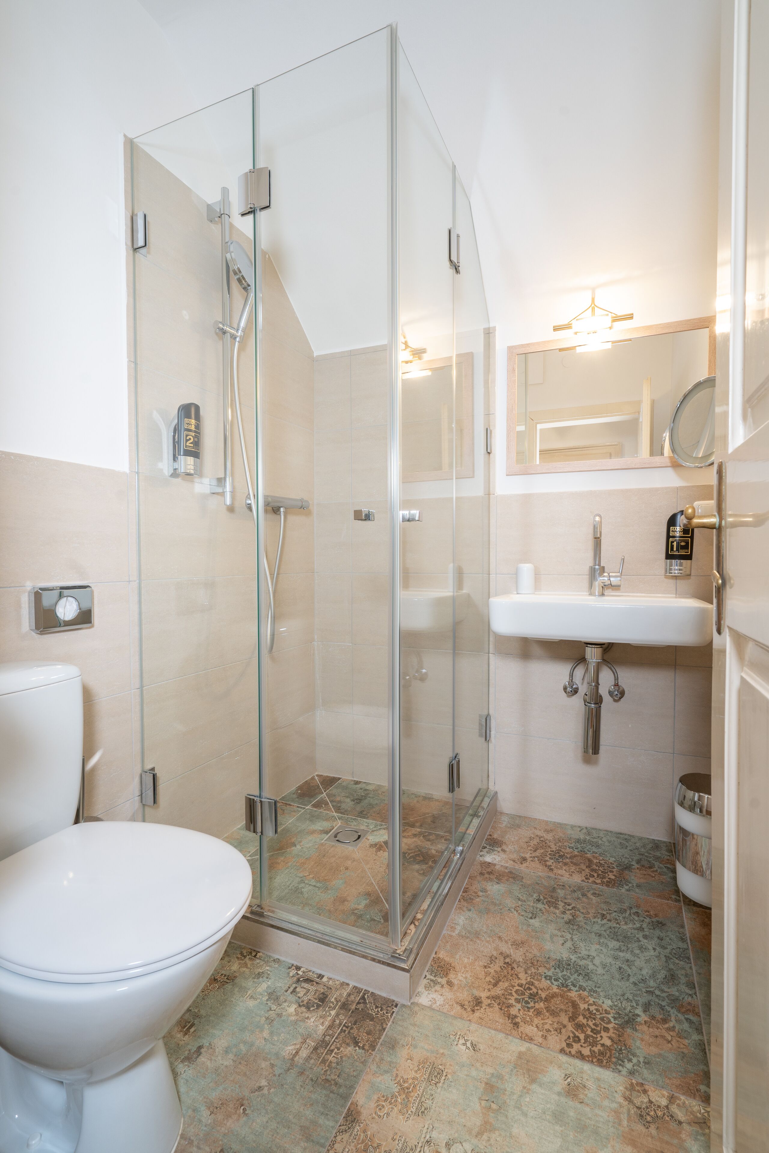 Un baño con ducha acristalada, un lavabo blanco y un inodoro.