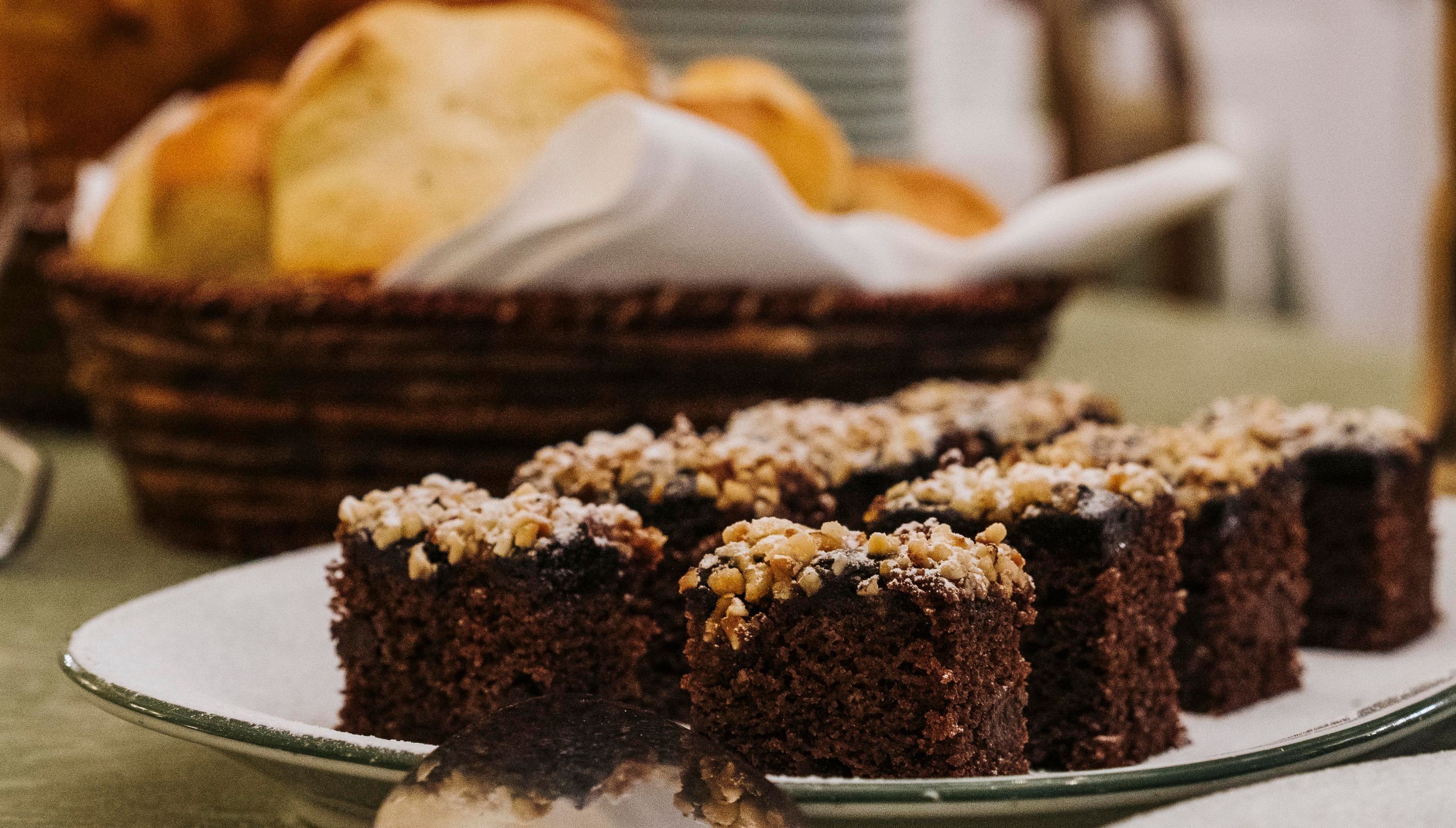 A plate of brownies with nuts on a table.