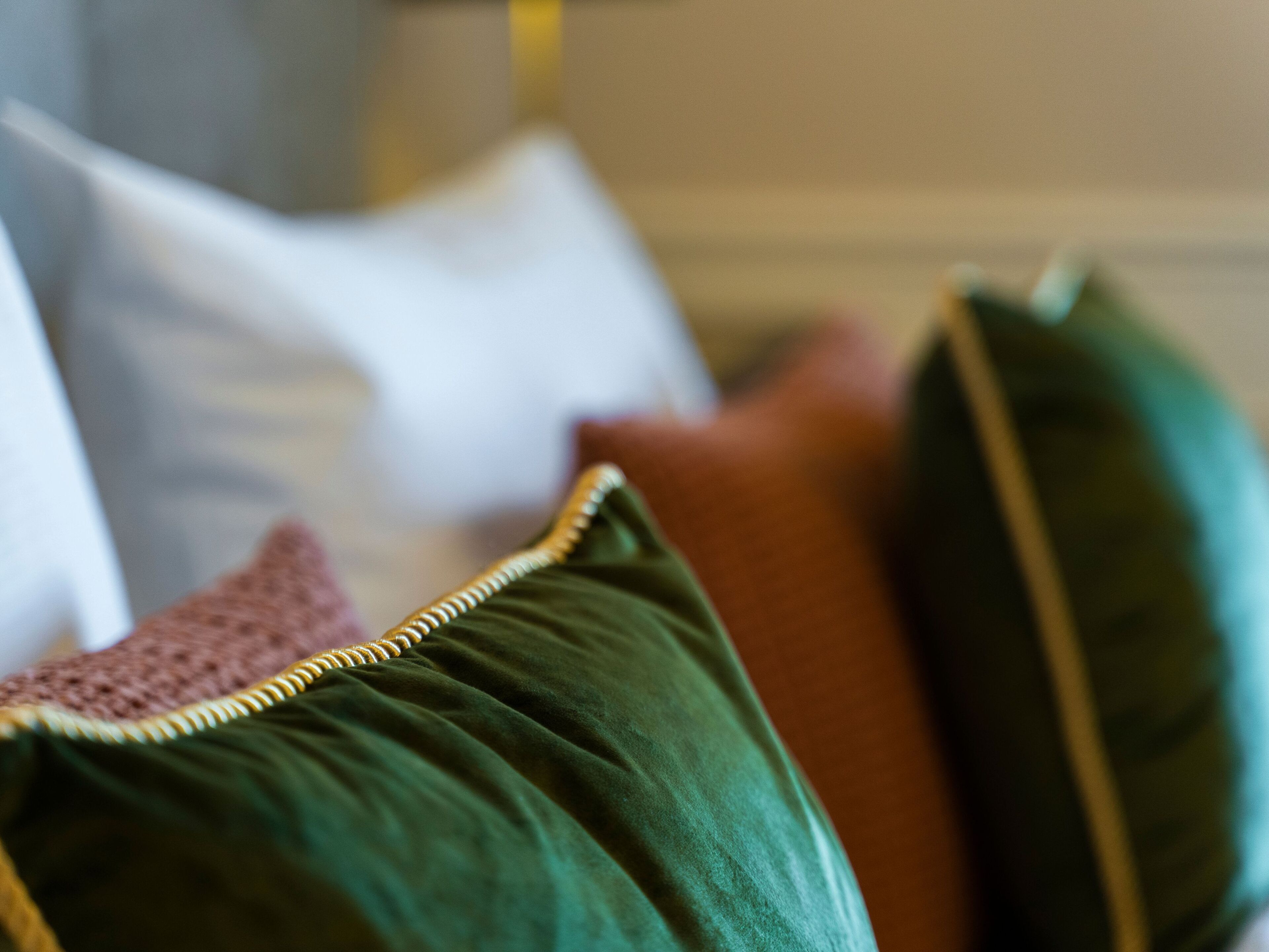 A close-up of a sofa with green and red cushions.