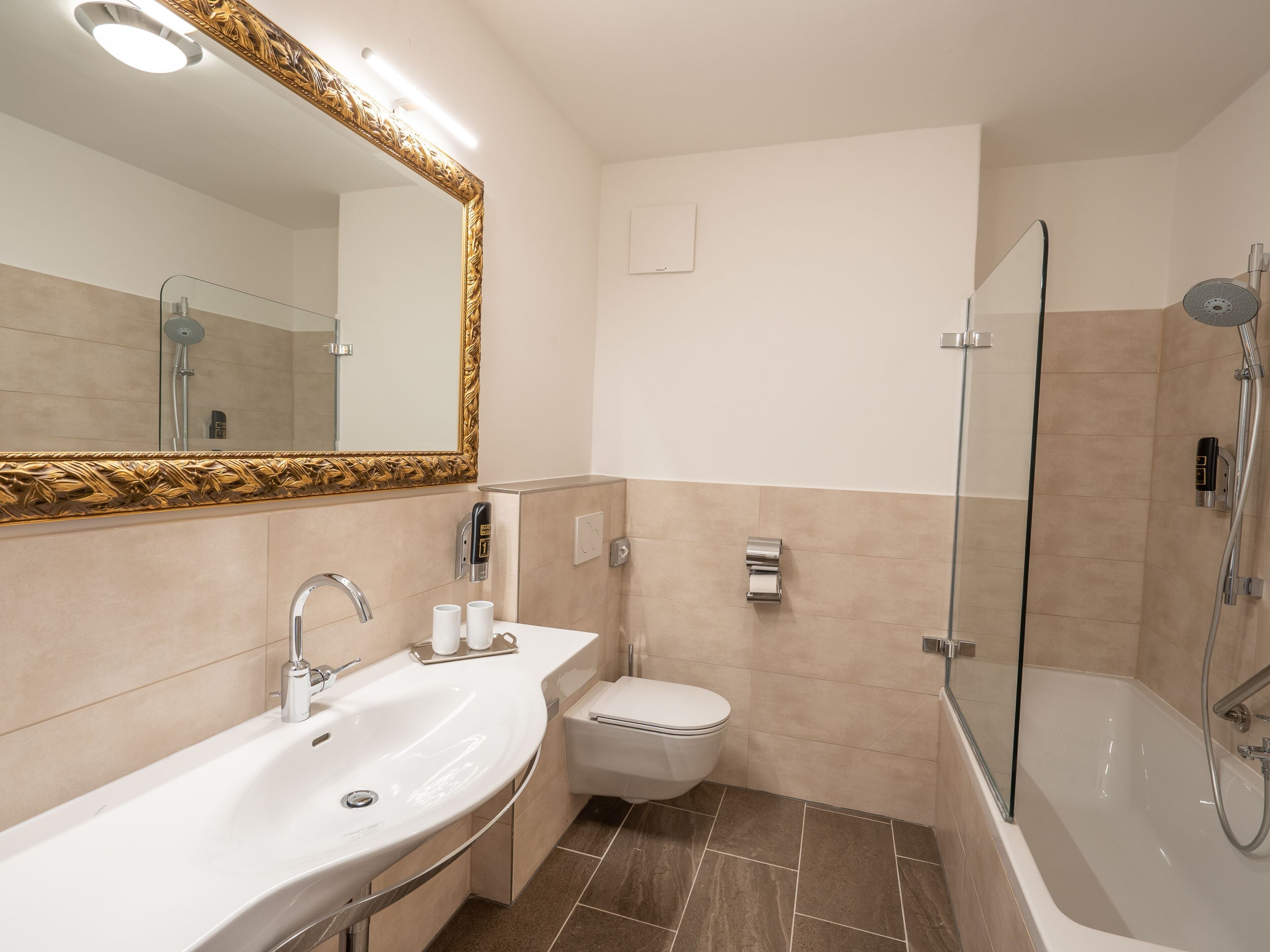 A modern bathroom with a sink, toilet, and shower.