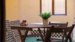 Une table en bois sur laquelle sont posés un pot de fleurs et un camion jouet.