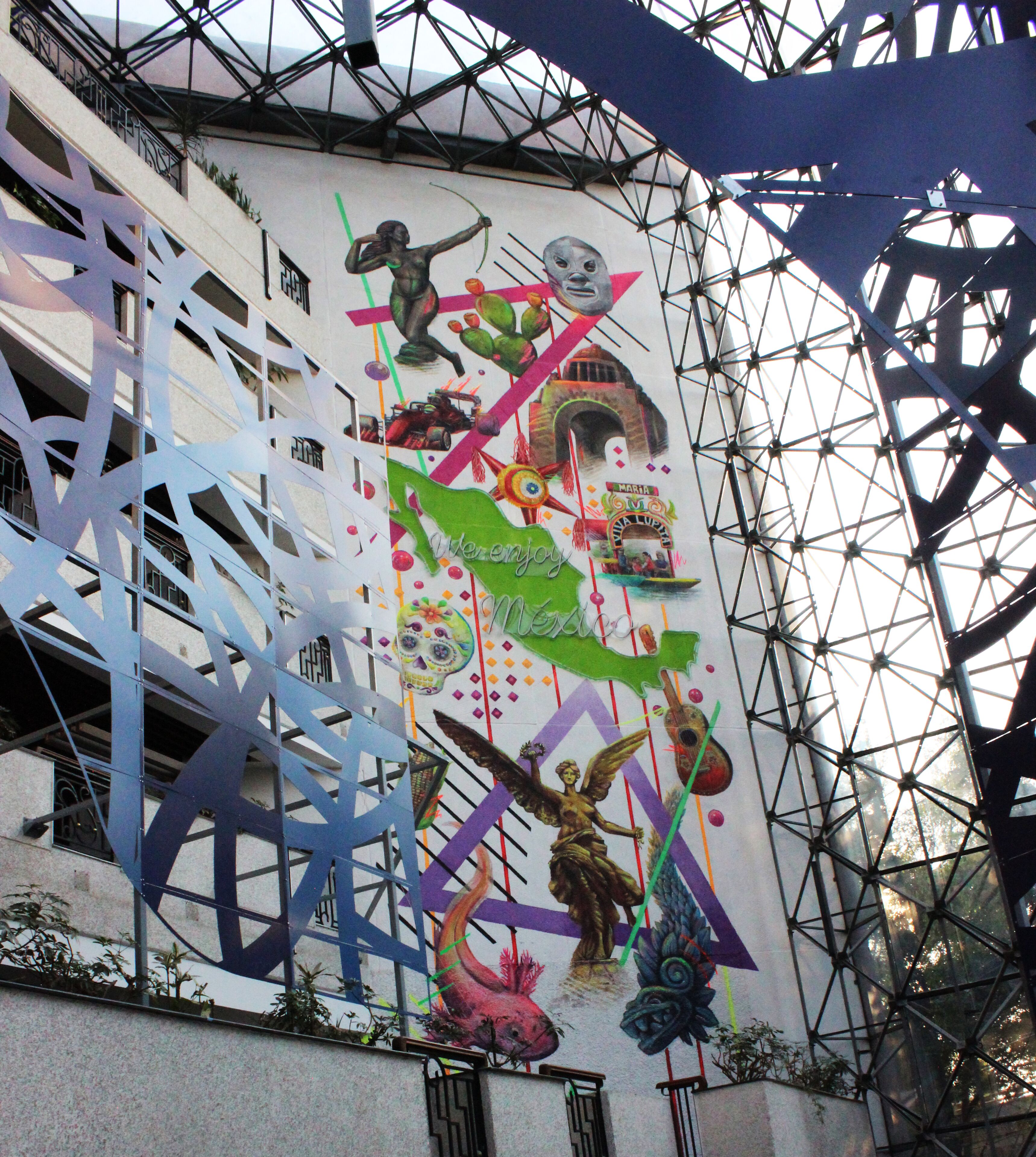 A building facade with a mural featuring various figures and symbols, including a skeleton, a woman, and a horse.
