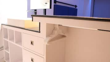 A white bathroom vanity with a mirror, a sink, and a towel rack.