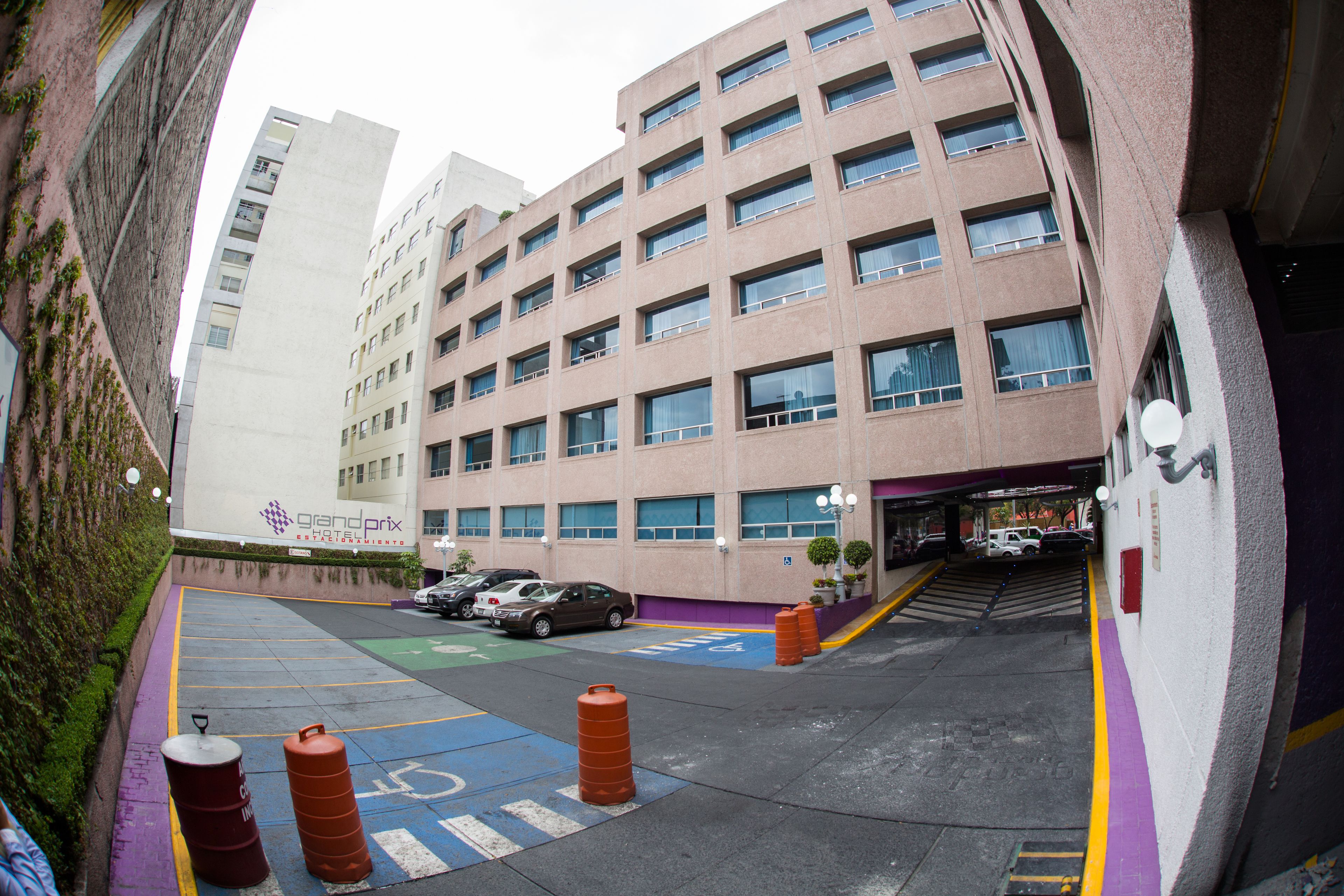 Un estacionamiento de varios pisos con vista despejada a la entrada y varios autos estacionados.