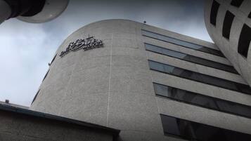 A modern hotel building with a curved facade and a sign reading "Hotel".