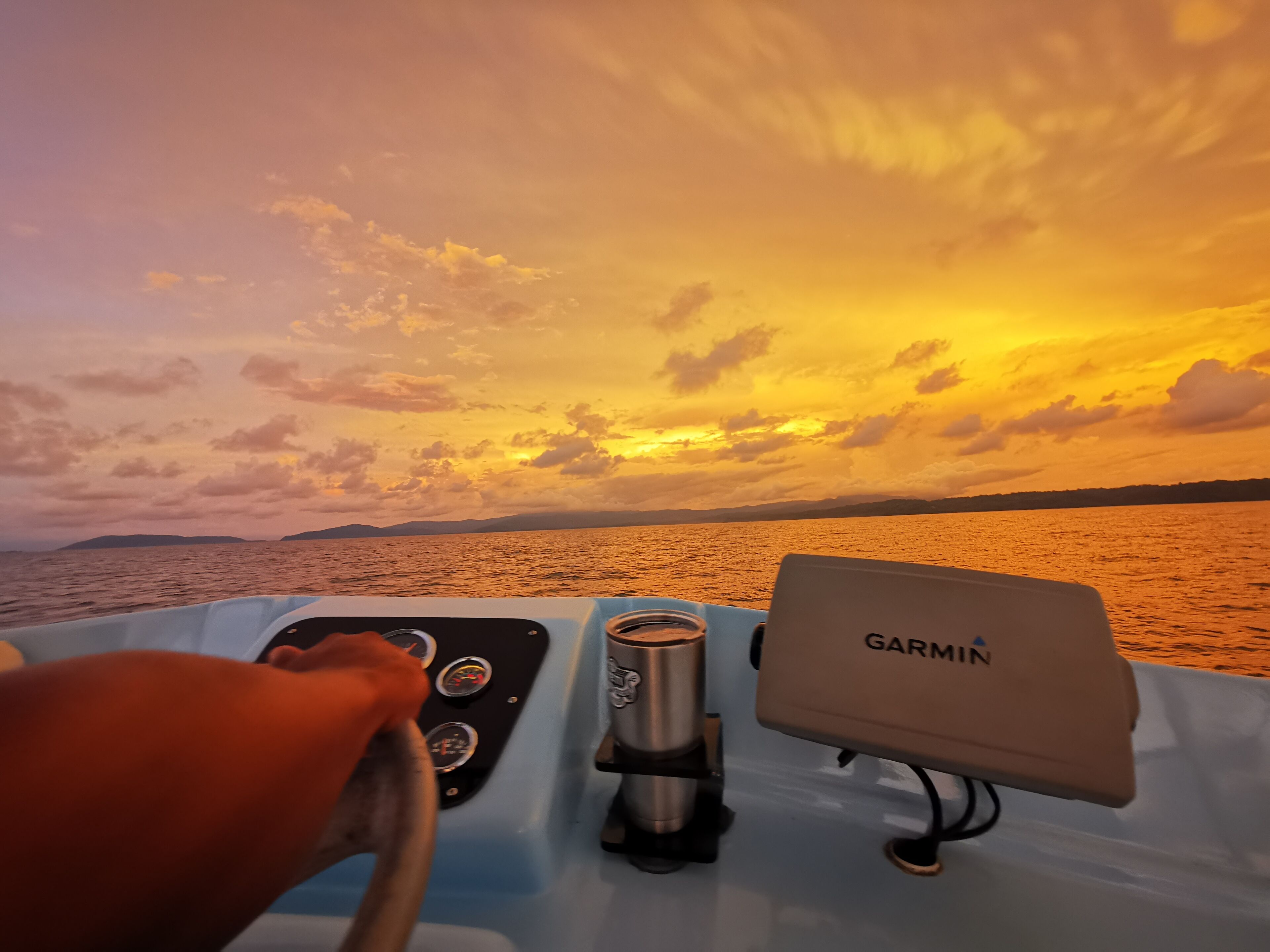 Un panneau de commande de bateau équipé d’un appareil Garmin et d’un volant.