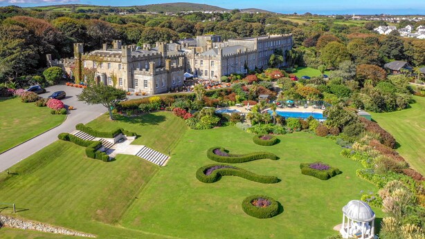 Un grand bâtiment historique doté d’un jardin à la française, d’une piscine et d’un belvédère.
