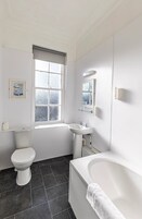 Un baño con inodoro, lavabo y bañera.