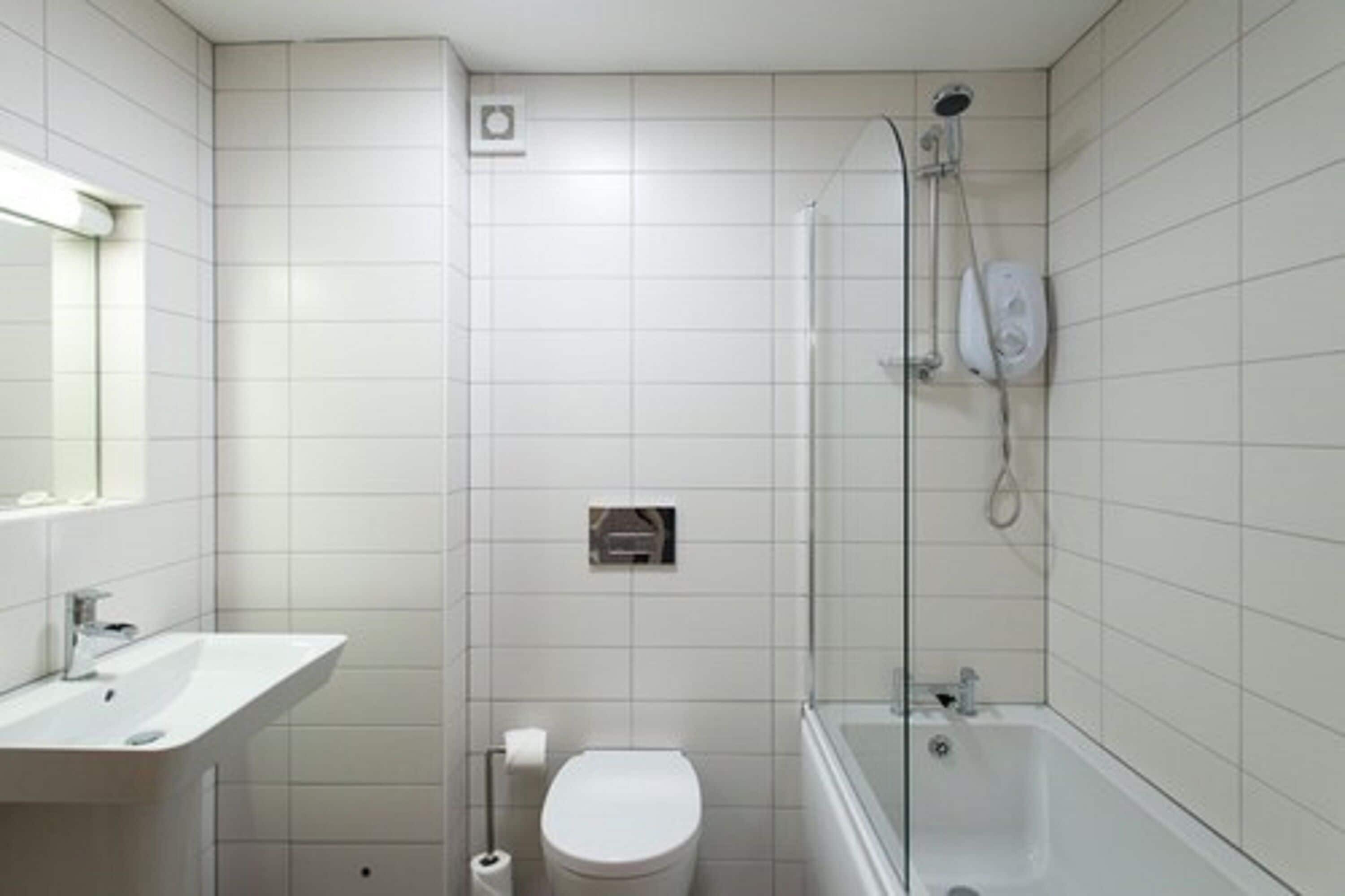 A bathroom with a toilet, sink, and bathtub.