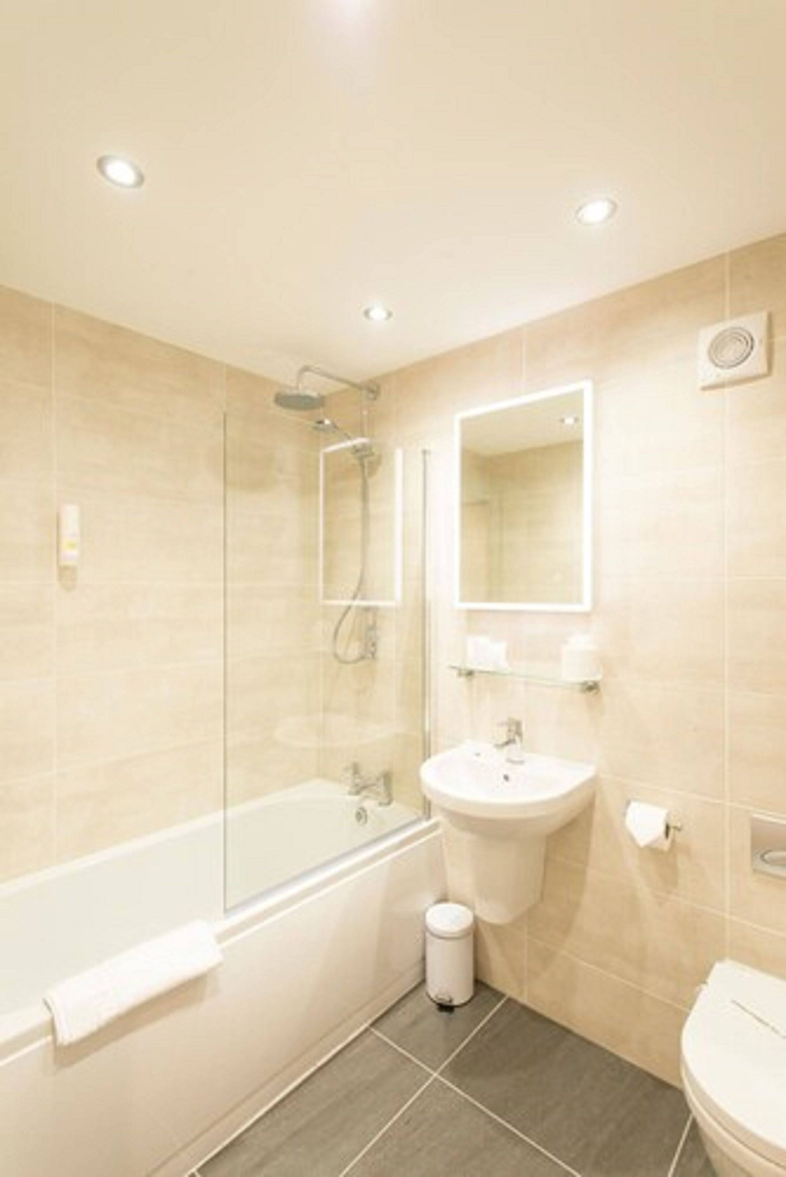 A modern bathroom with a glass-enclosed shower, a sink, and a toilet.