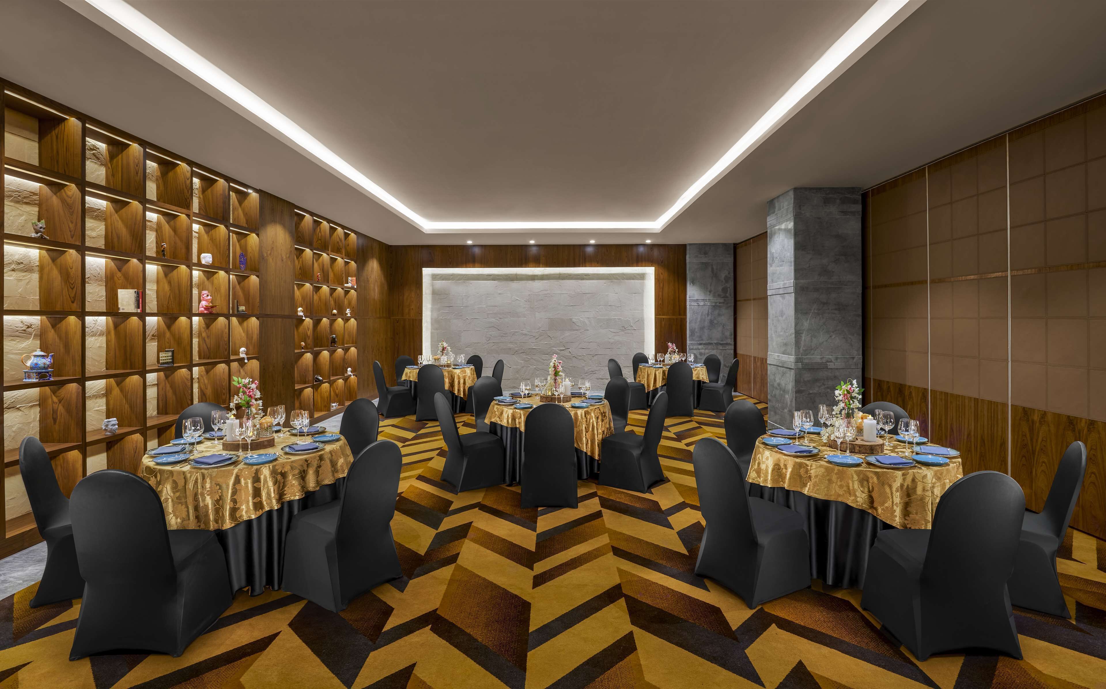 A conference room with multiple tables set for dining, equipped with chairs and table settings.