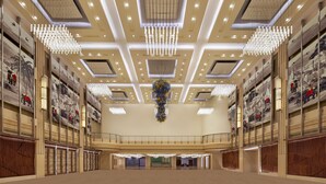 Ein geräumiger Innenhof mit hohen Decken, modernen Kronleuchtern und Kunstwerken an den Wänden.