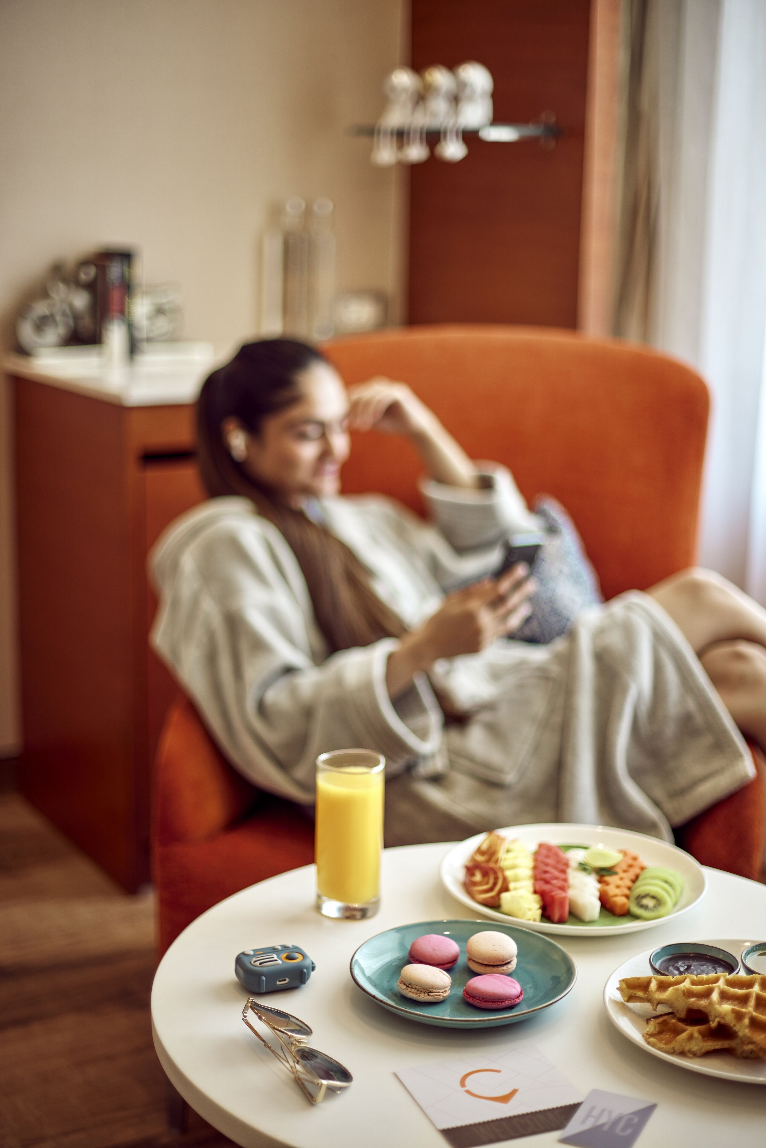 Une personne est assise sur une chaise devant une table sur laquelle se trouvent de la nourriture et une boisson.