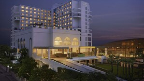 Ein mehrstöckiges Hotel mit modernem Design, das ein zentrales Atrium und zahlreiche Balkone bietet.