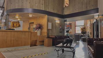 A lobby with a reception desk, seating area, and a staircase.