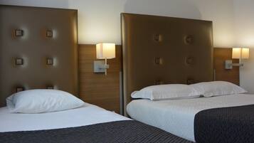 Twee bedden met hoofdeinden, elk met een wandlamp.