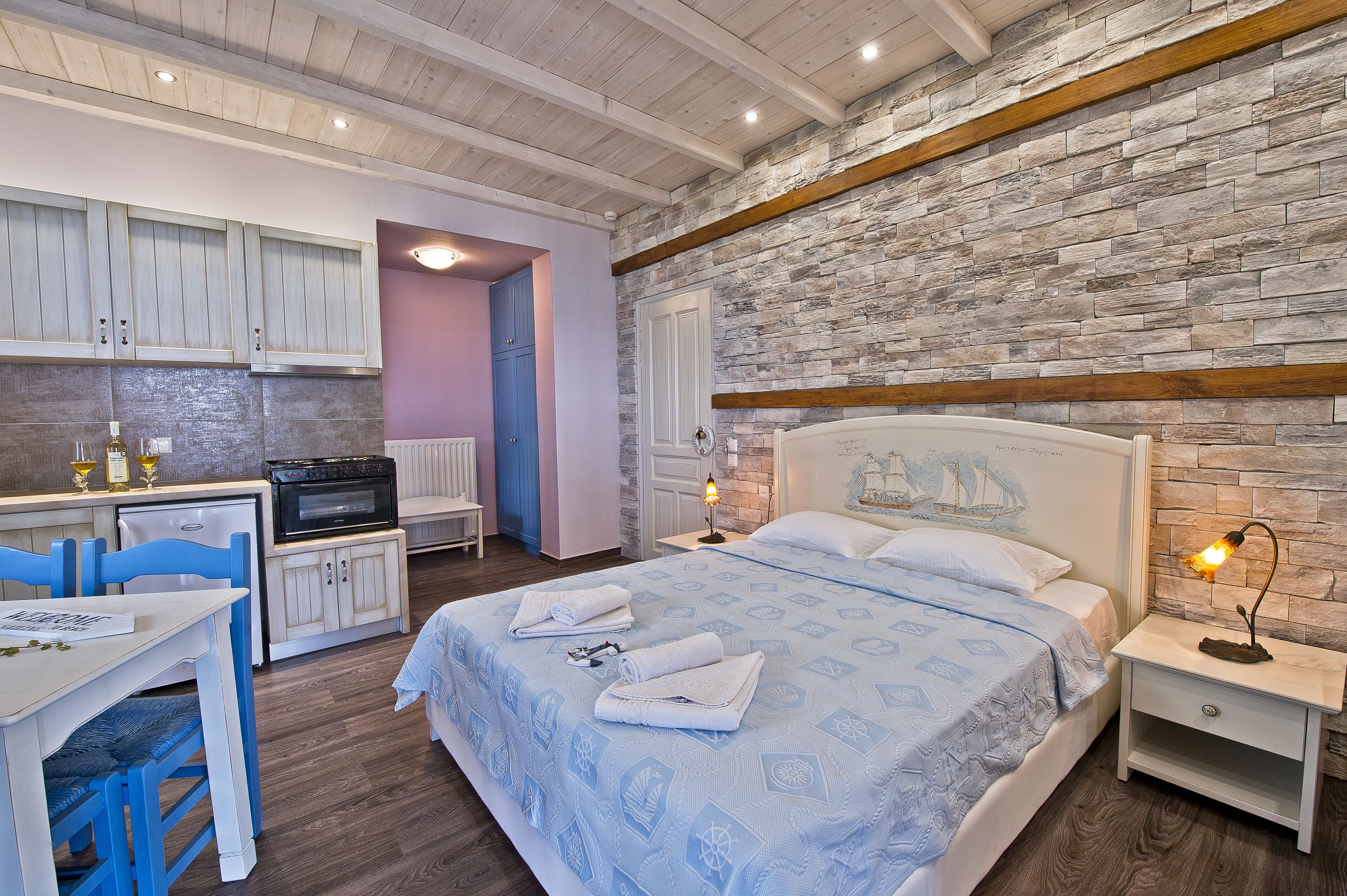 Ein Zimmer mit einem Bett, einem Schreibtisch und einer Küchenzeile.
