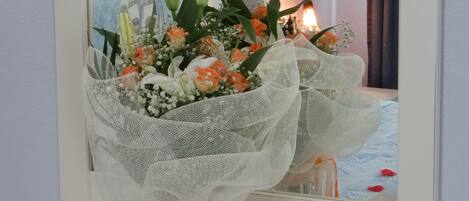 Un ramo de flores en un jarrón sobre una cómoda con un espejo encima.