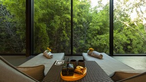 A room with two reclining chairs, a tray with a teapot, cups, and food, and a large window with a view of dense green foliage. - Douro Palace Hotel Resort and Spa (Baiao)