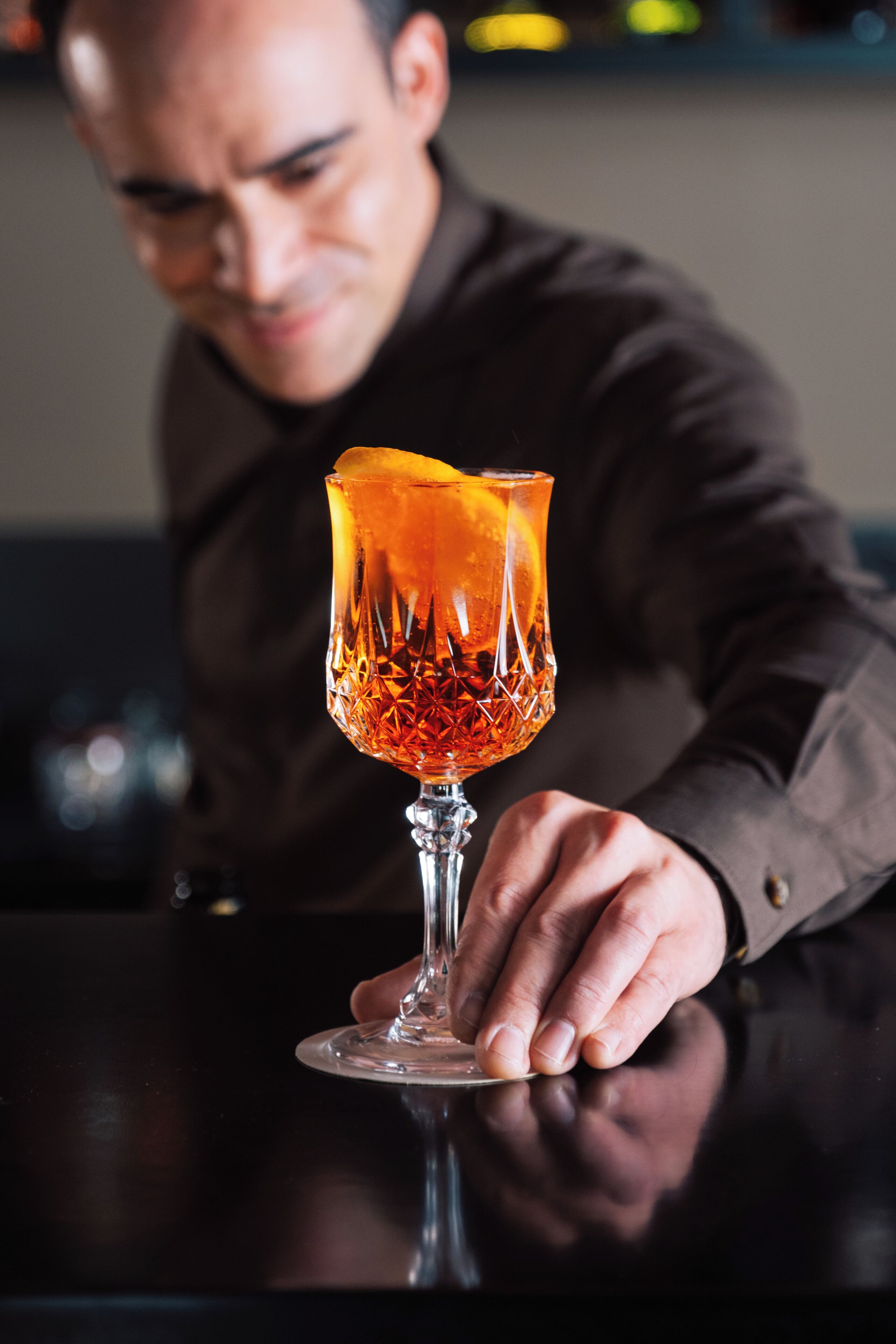 A person holding a glass with a textured pattern.