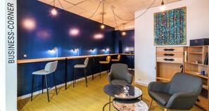 Un espace de travail moderne avec un mur d’accent bleu, un bureau en bois et des sièges confortables.