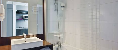 A modern bathroom with a glass-enclosed shower, a white sink, and a mirror above the sink.