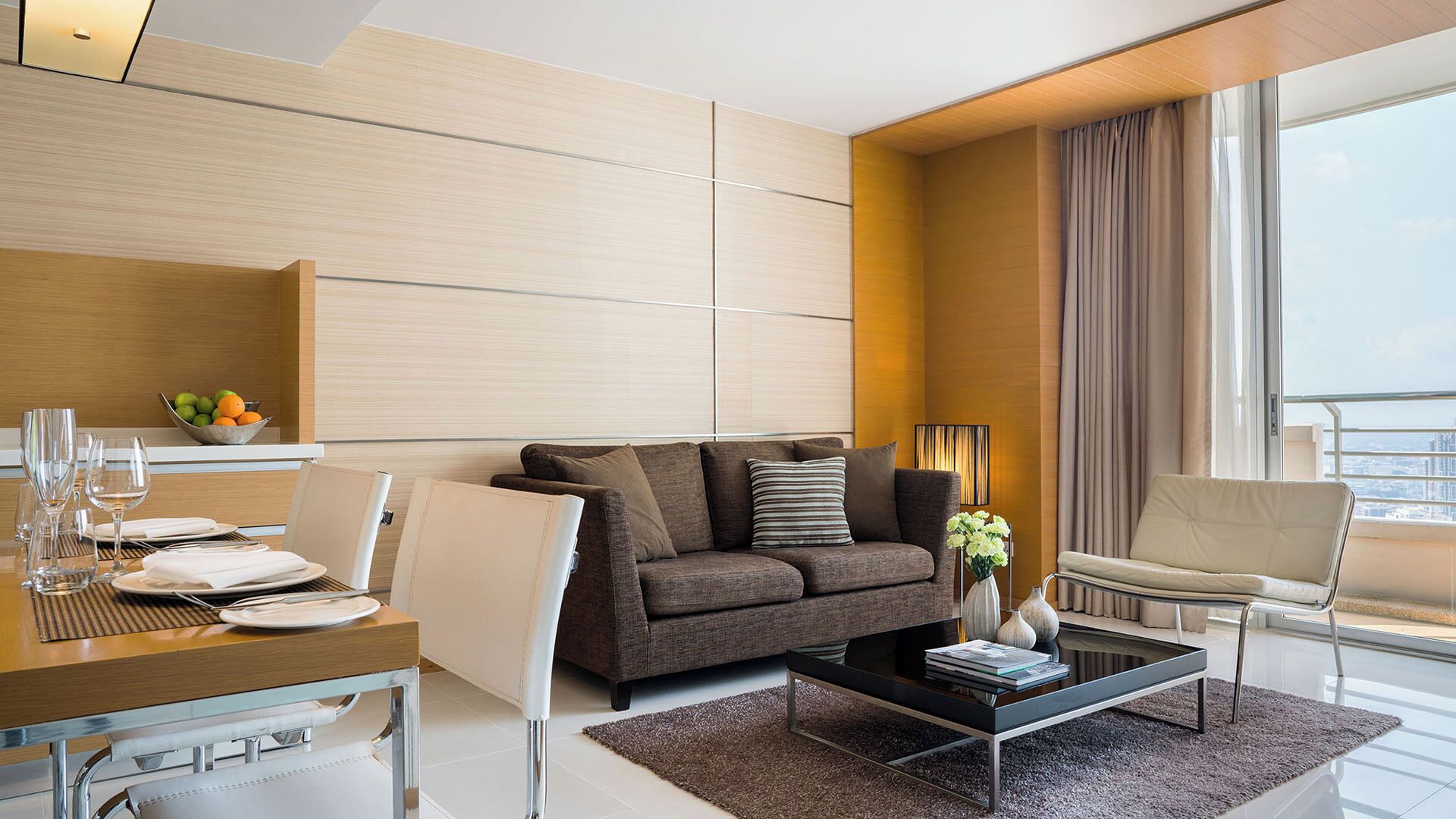 Een moderne woonkamer met een bank, salontafel en een eethoek.