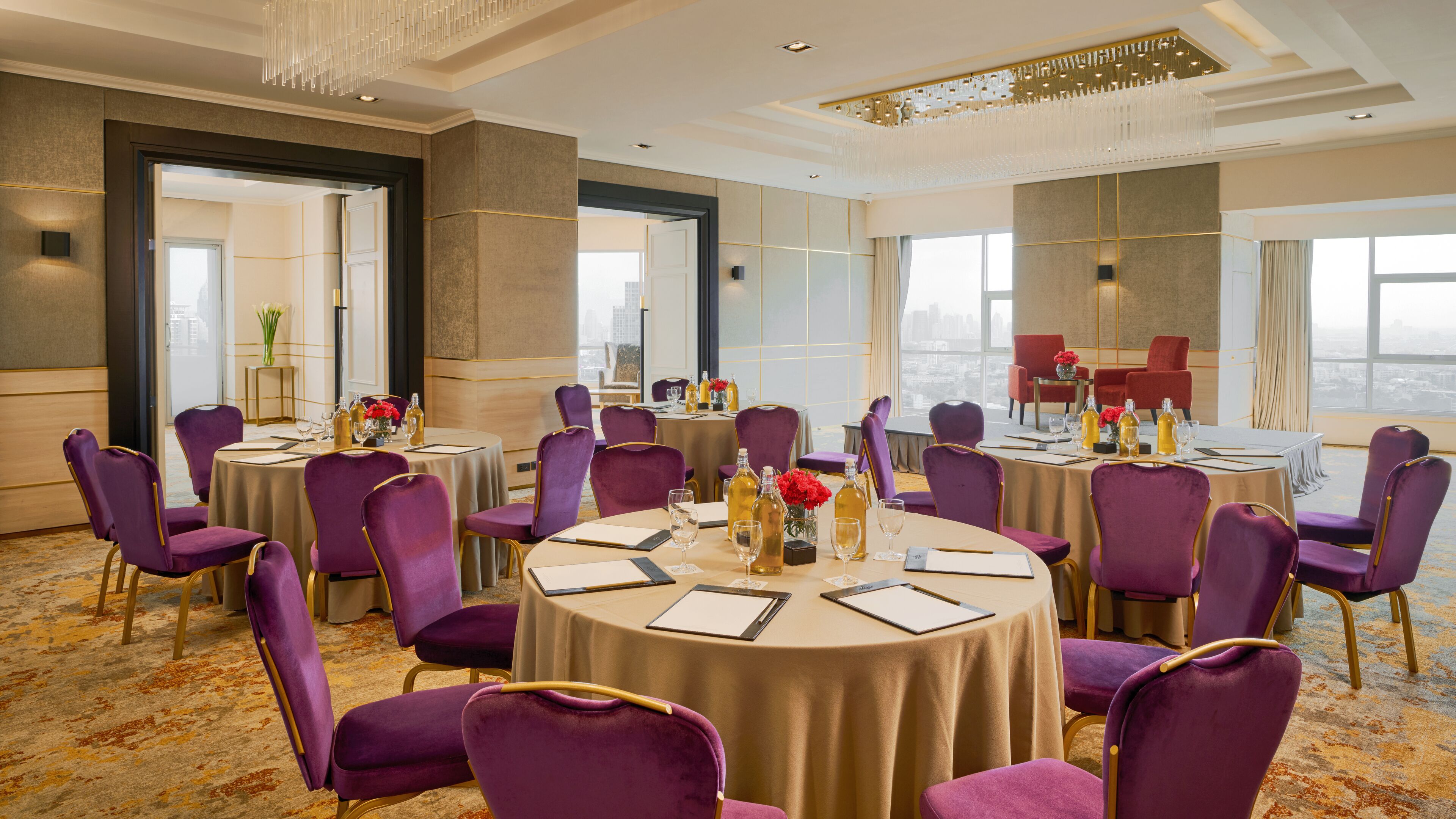 A conference room with round tables, purple chairs, and a city view.