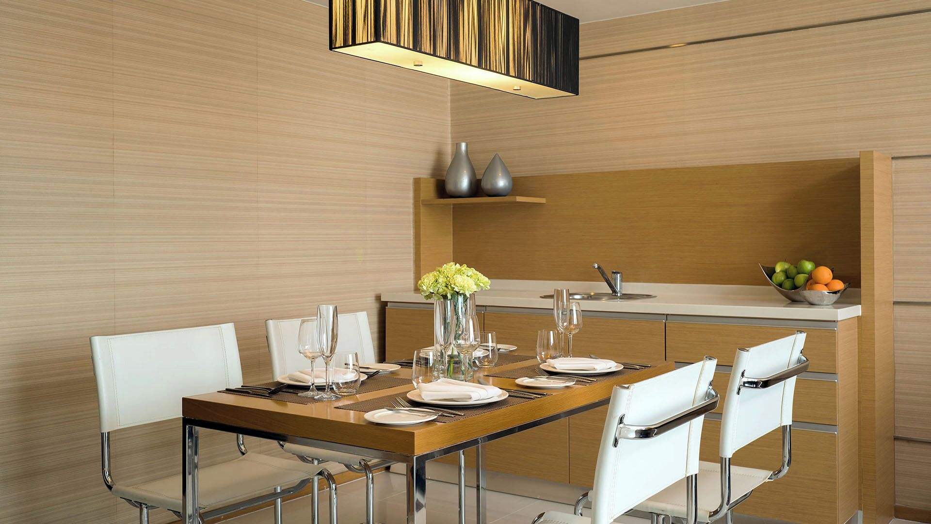 A modern dining area with a wooden table, white chairs, and a central vase with flowers.