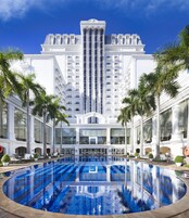 Una piscina al aire libre, sombrillas, sillones reclinables de piscina