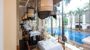 Un restaurante con mesas dispuestas para comer, con vistas a una piscina.