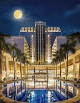 Una piscina al aire libre, sombrillas, sillones reclinables de piscina